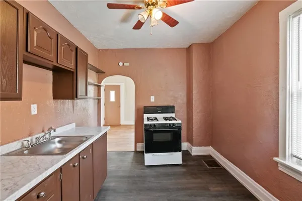 a kitchen with stainless steel appliances granite countertop a sink a stove and a wooden floors