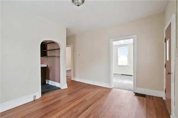 an empty room with wooden floor and closet