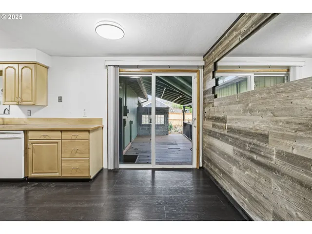 a hallway with cabinets wooden floor and a front door