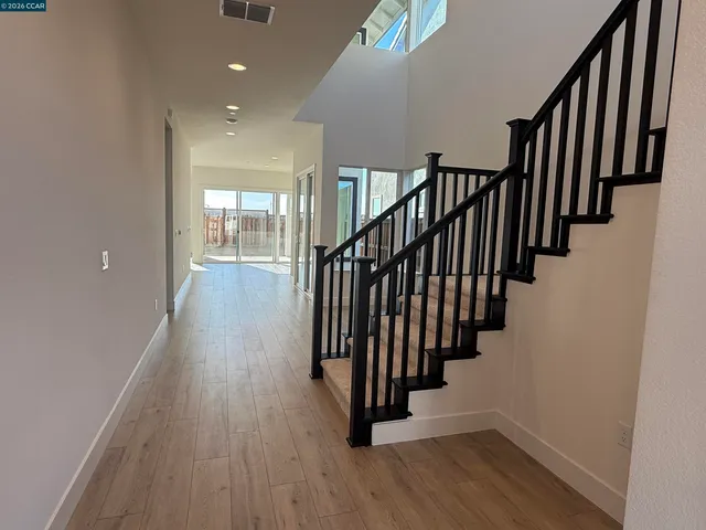 a view of a hallway with wooden floor and staircase