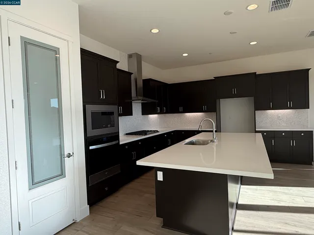 a view of kitchen with refrigerator and microwave