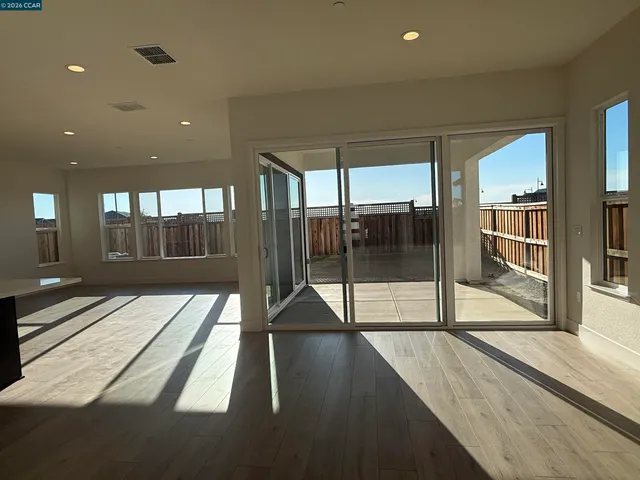 a view of a large hall with a floor to ceiling window and wooden floor
