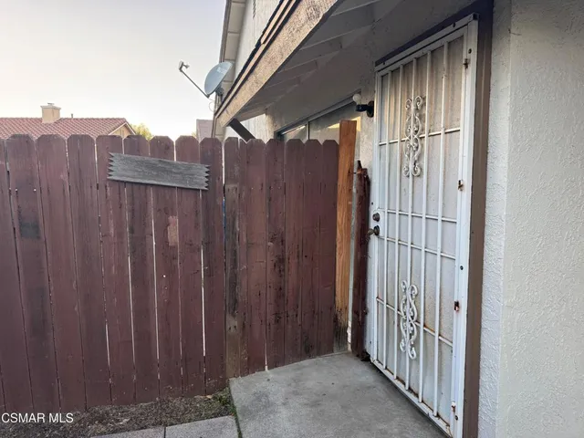 a view of a house with wooden fence