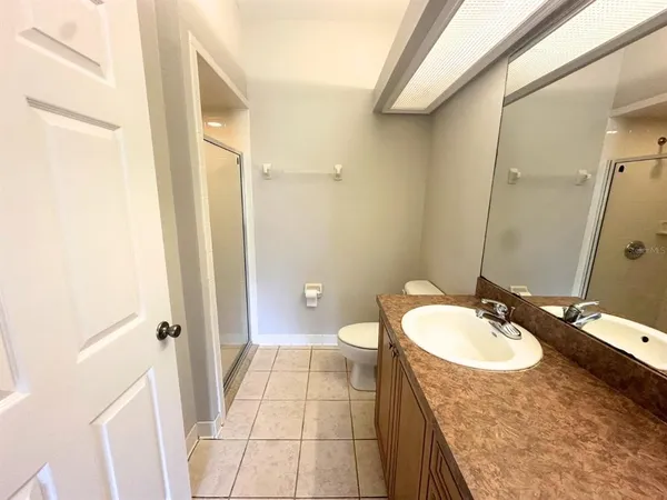 a bathroom with a granite countertop sink a mirror and a toilet