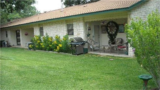 a view of a chair and table in back yard of the house