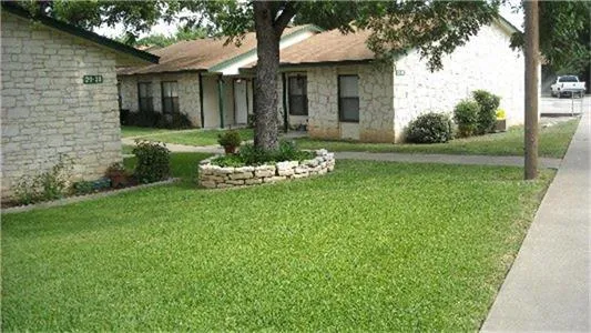 a front view of a house with a yard and fountain