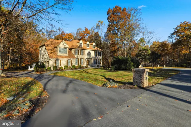 a view of a big house with a big yard and large trees