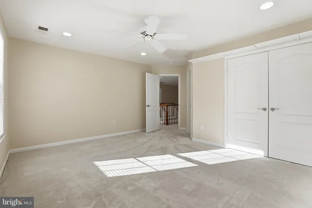 a large bedroom with a bed and a lamp