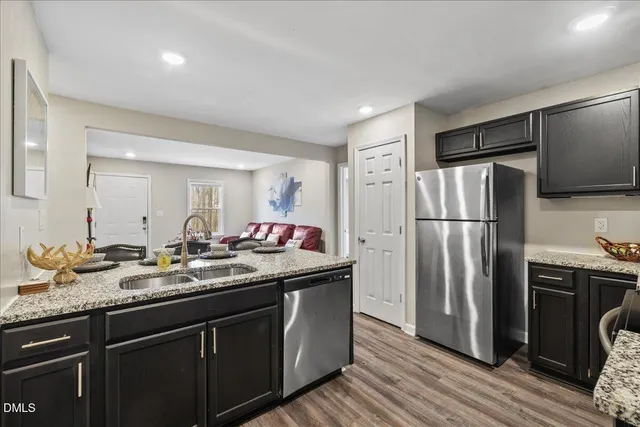a kitchen with granite countertop a refrigerator and a sink