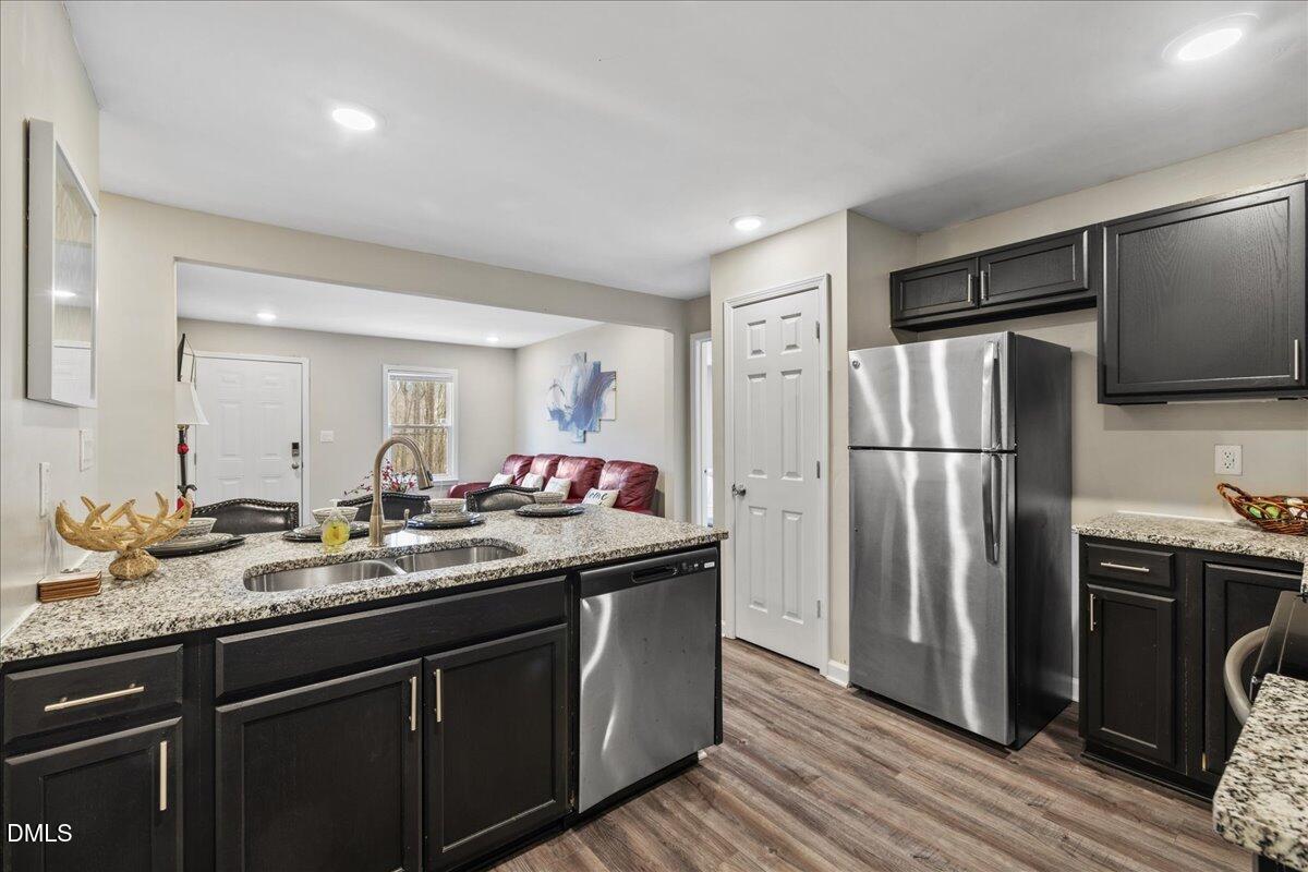513 Broad Street Roxboro, NC 27573 - Photo 12 of 33 a kitchen with granite countertop a refrigerator and a sink
