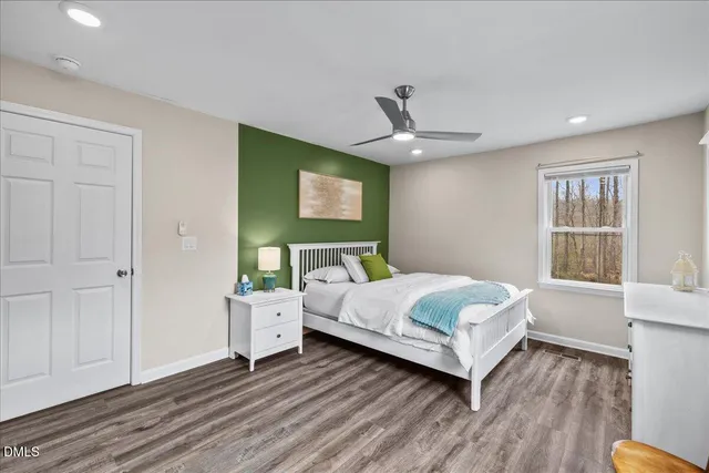 a bedroom with a large bed a chandelier and a window