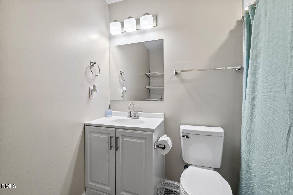 513 Broad Street Roxboro, NC 27573 - Photo 27 of 33 a bathroom with a toilet a sink and mirror