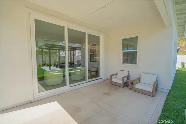 a view of a patio with a table chairs and a floor to ceiling window