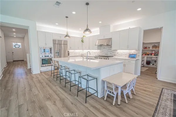a kitchen with granite countertop white cabinets and stainless steel appliances