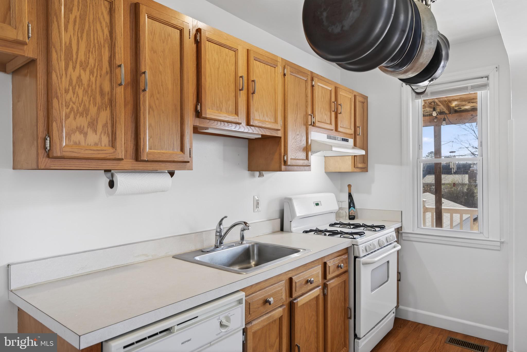 3579 Benzinger Road Baltimore, MD 21229 - Photo 12 of 34 a kitchen with stainless steel appliances granite countertop a sink a stove and a wooden floors