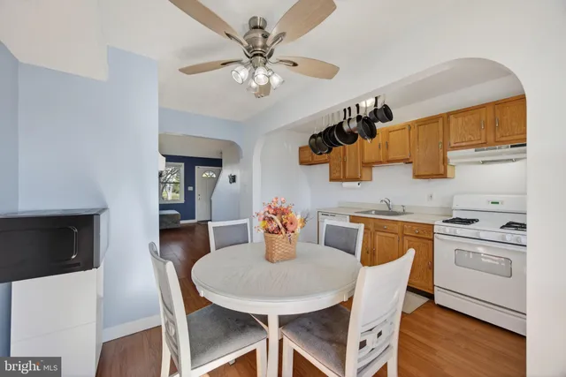 a kitchen with stainless steel appliances granite countertop a dining table chairs and a refrigerator