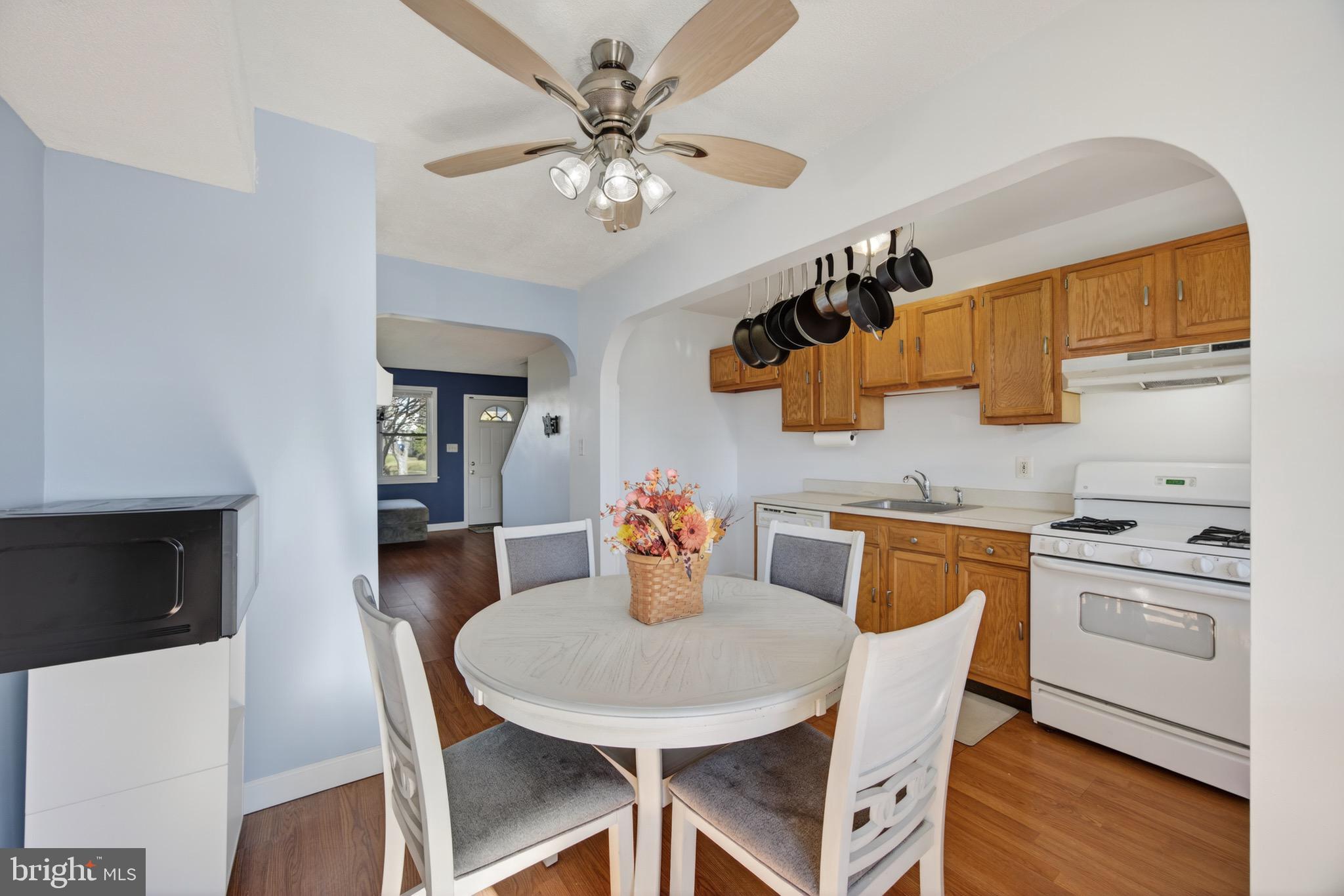 3579 Benzinger Road Baltimore, MD 21229 - Photo 17 of 34 a kitchen with stainless steel appliances granite countertop a dining table chairs and a refrigerator
