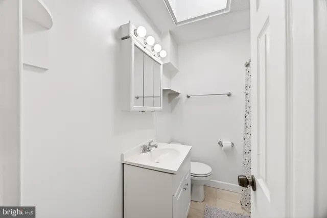 a bathroom with a toilet a sink and mirror