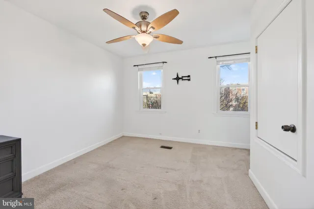 an empty room with a window and a ceiling fan