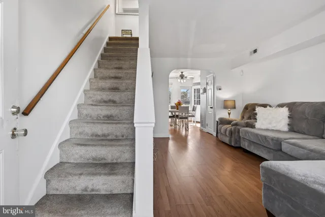 a living room with furniture and a dining table with wooden floor