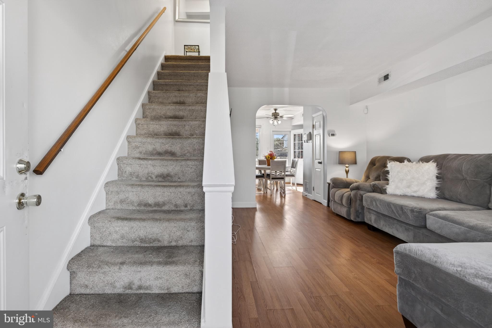 3579 Benzinger Road Baltimore, MD 21229 - Photo 5 of 34 a living room with furniture and a dining table with wooden floor