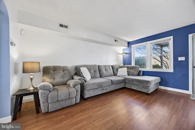 a living room with furniture and a wooden floor