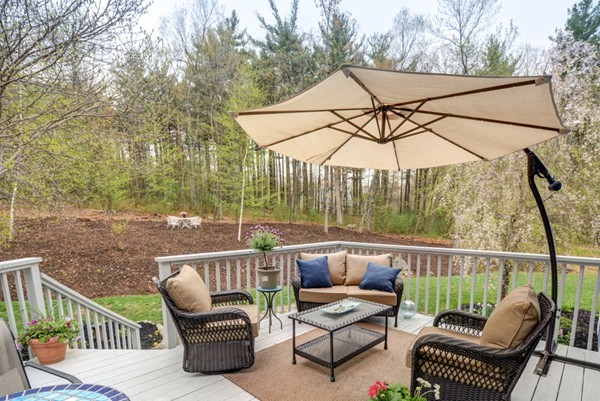 149 Nourse Road Bolton, MA 01740 - Photo 25 of 30 a view of a patio with couches chairs under an umbrella