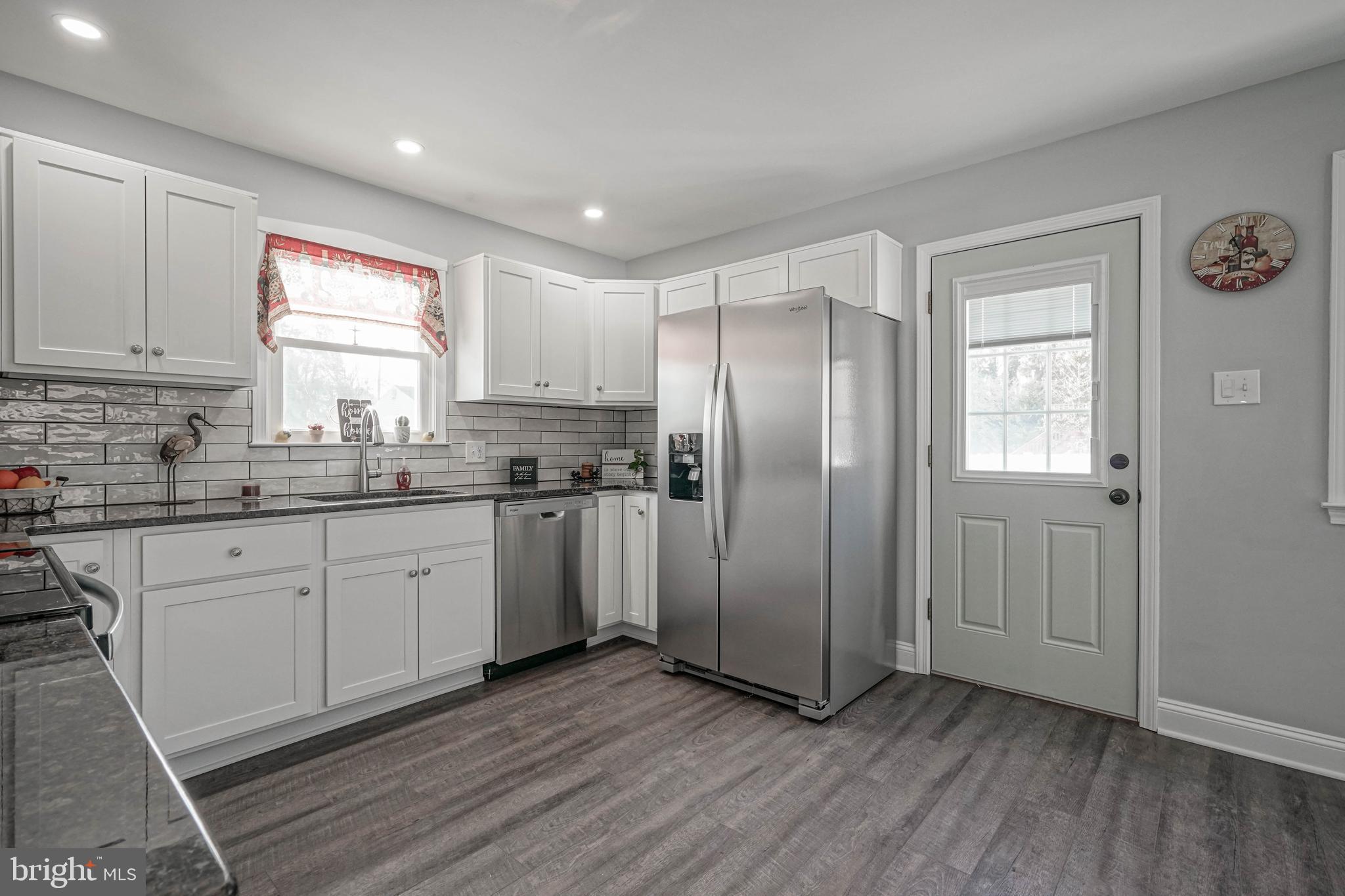 8 Riviera Drive Pennsville, NJ 08070 - Photo 11 of 31 a kitchen with stainless steel appliances granite countertop a refrigerator a sink and white cabinets with wooden floor
