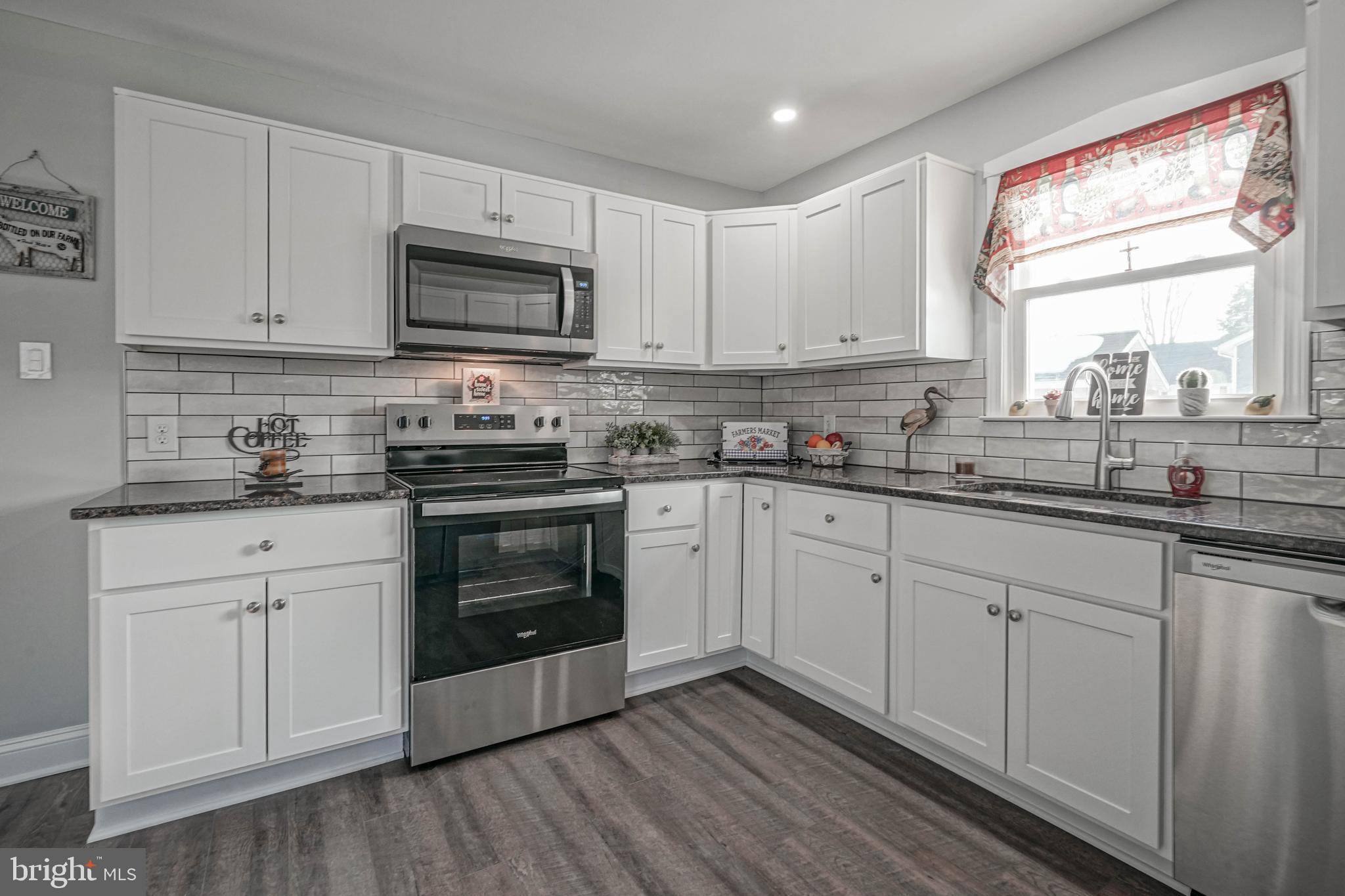 8 Riviera Drive Pennsville, NJ 08070 - Photo 12 of 31 a kitchen with stainless steel appliances white cabinets granite counter tops and a window