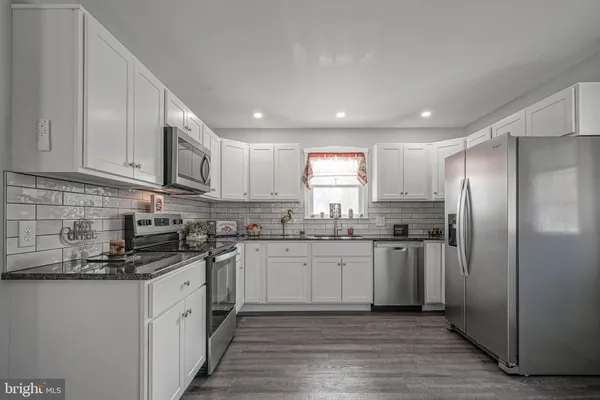 a kitchen with stainless steel appliances granite countertop a refrigerator sink and cabinets
