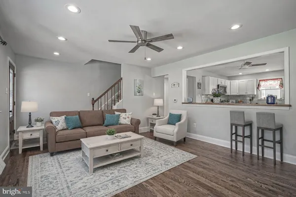 a living room with furniture and kitchen view