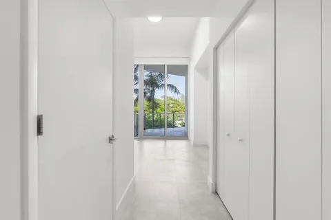 a view of a hallway with wooden floor and a potted plant