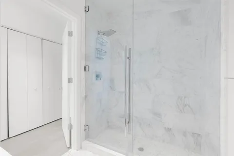an empty room with glass door and shower