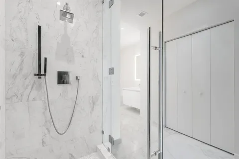 a bathroom with a shower and a glass door