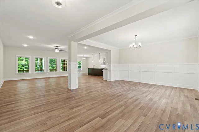 a view of a big room with wooden floor and a kitchen