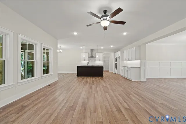 a room with kitchen island sink and wooden floor