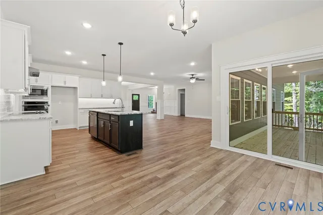 a kitchen that has a sink a stove a dining table and chairs in it
