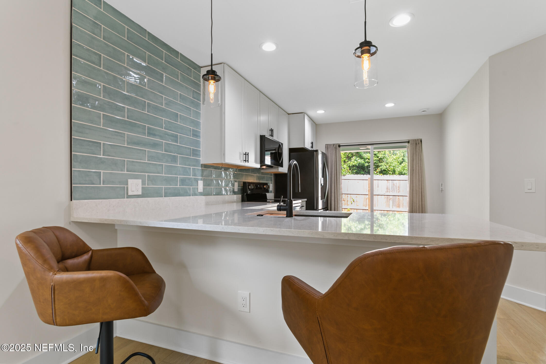16 Sidney Street St. Augustine, FL 32084 - Photo 5 of 38 a kitchen with stainless steel appliances granite countertop a sink a window and chairs