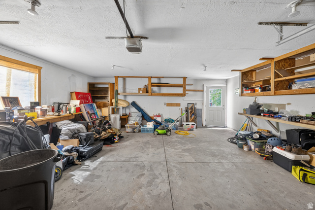 730 East 200 North Logan, UT 84321 - Photo 24 of 28 Spacious garage with concrete flooring, multiple built-in shelving units, and a large window providing natural light