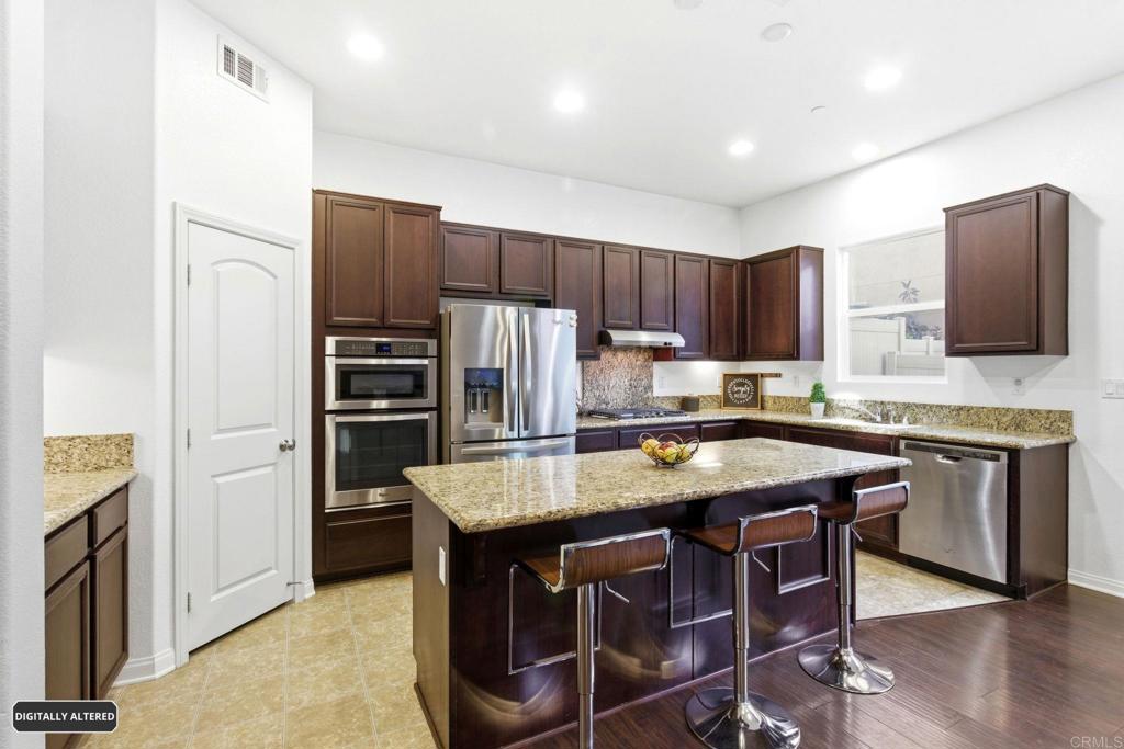 1508 Carpinteria Street Chula Vista, CA 91913 - Photo 7 of 39 a kitchen with kitchen island granite countertop wooden cabinets a refrigerator and a stove