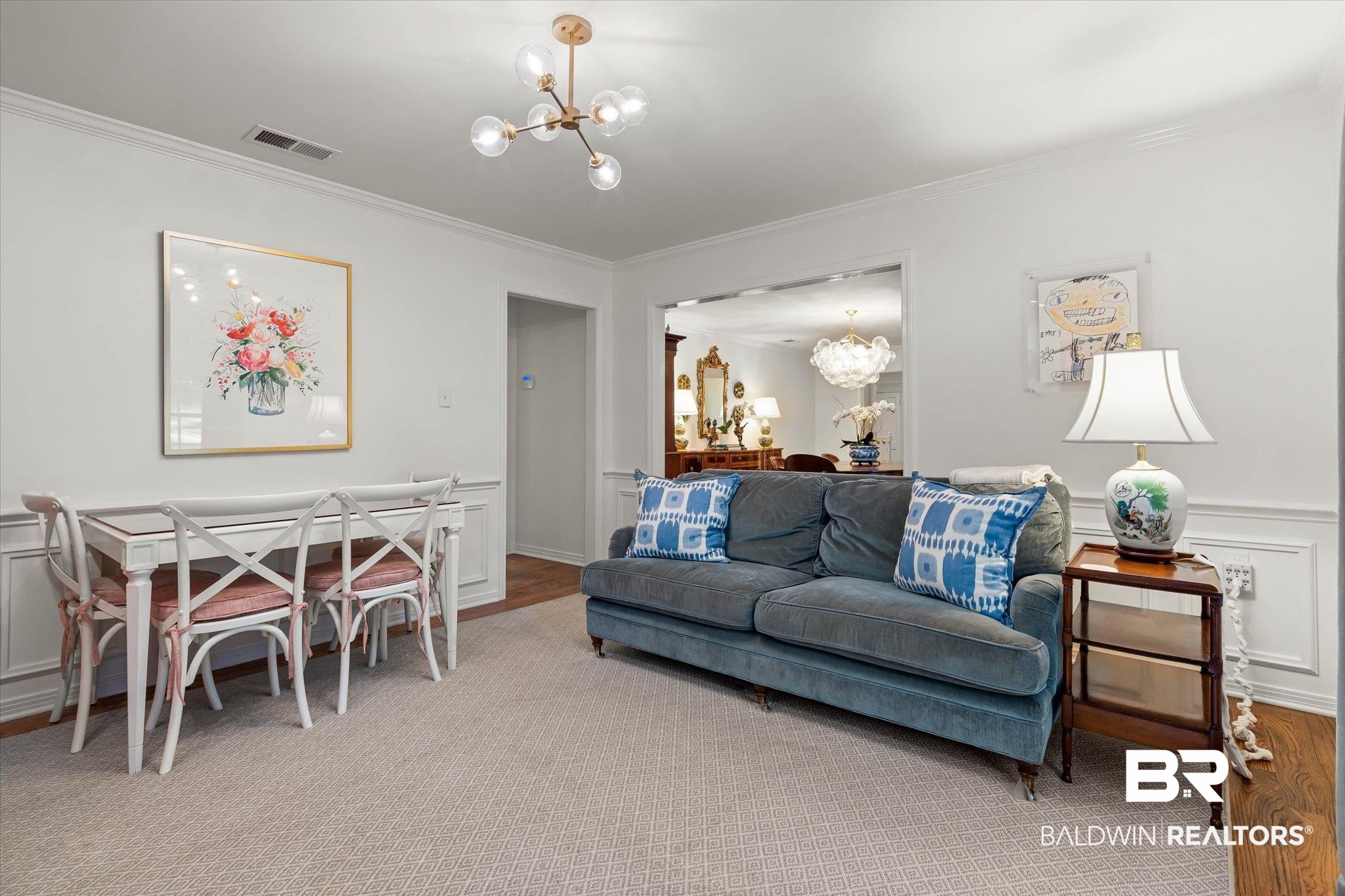 3612 Linden Lane Mobile, AL 36608 - Photo 9 of 42 Living room featuring a chandelier, ornamental molding, a decorative wall, a wainscoted wall, and carpet floors