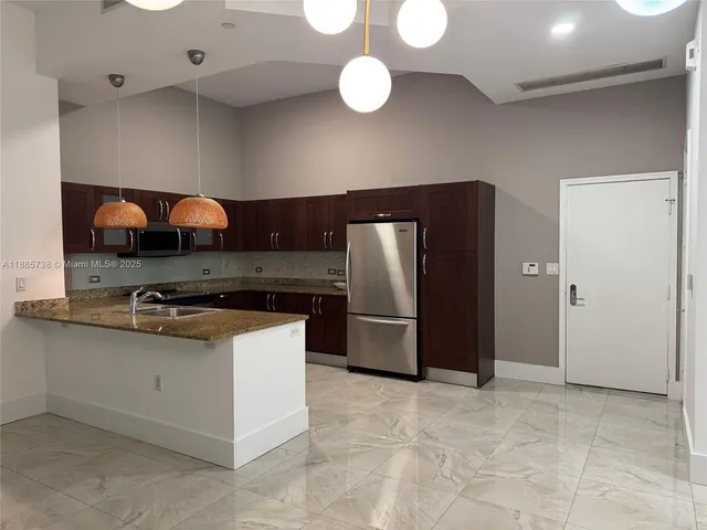 a kitchen with stainless steel appliances granite countertop a stove a refrigerator and a sink