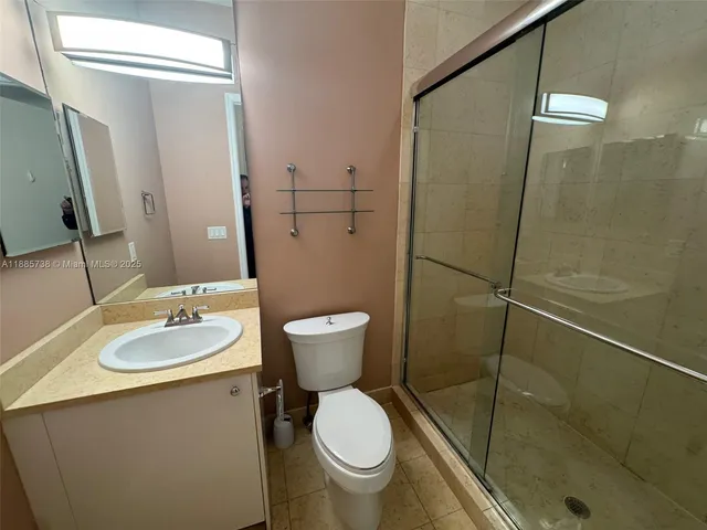 a bathroom with a granite countertop toilet a sink and a mirror