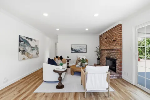 a living room with furniture a fireplace and a window