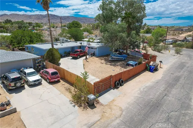 a roof deck with table and chairs and potted plants