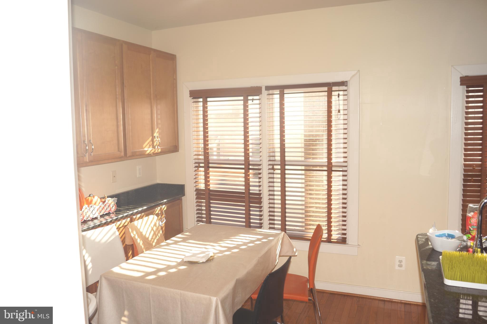 2338 Cobble Hill Terrace Silver Spring, MD 20902 - Photo 17 of 25 a kitchen with a table chairs and wooden floor