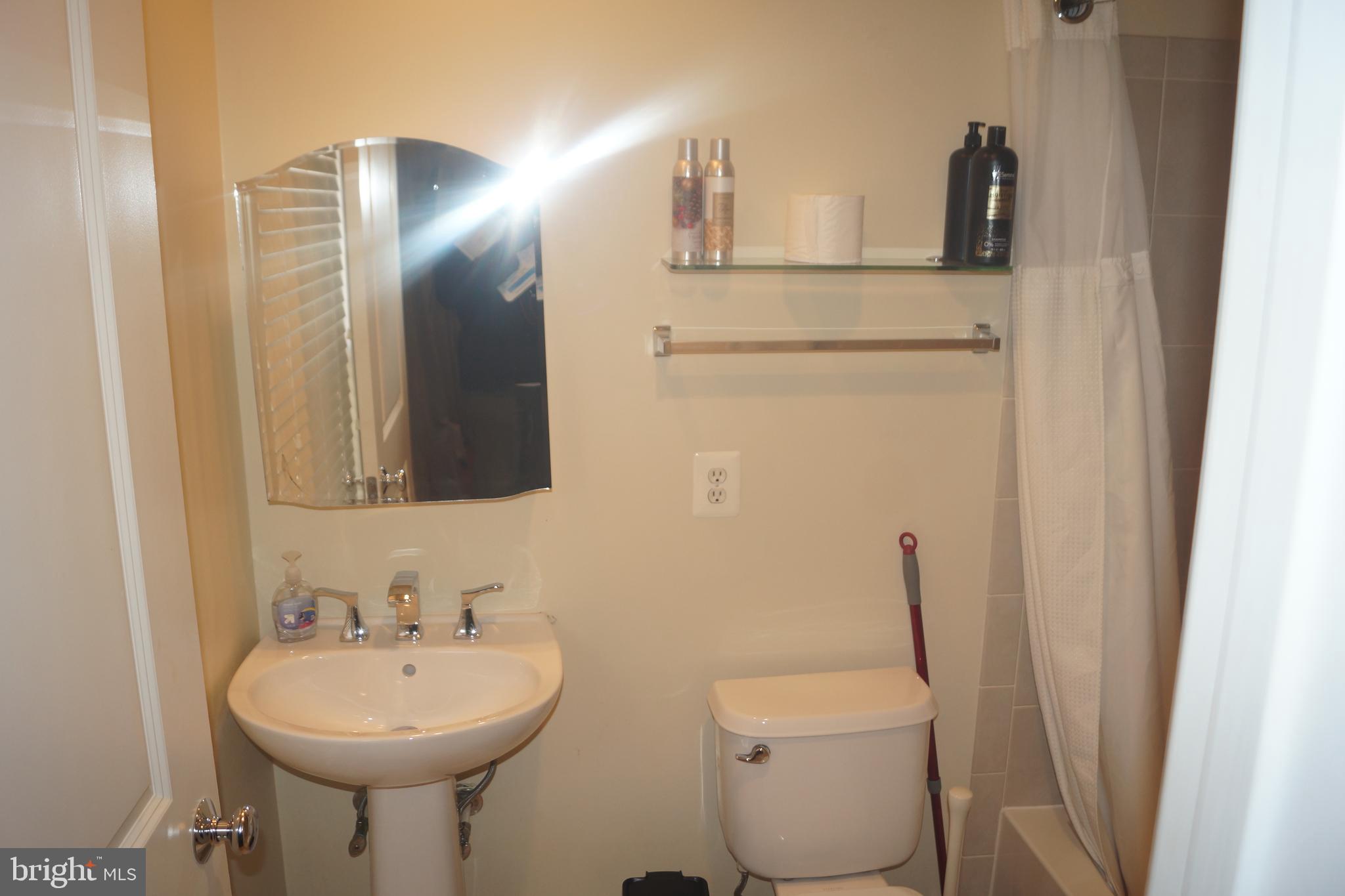 2338 Cobble Hill Terrace Silver Spring, MD 20902 - Photo 24 of 25 a bathroom with a toilet sink and mirror