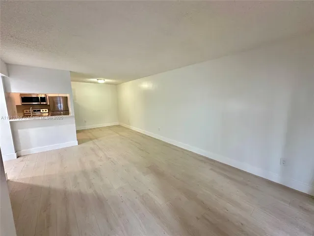 a view of a room with wooden floor and windows