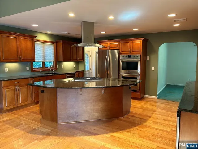 a kitchen with stainless steel appliances kitchen island granite countertop a stove a sink and a microwave