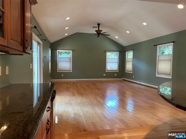 a view of empty room with window and wooden floor